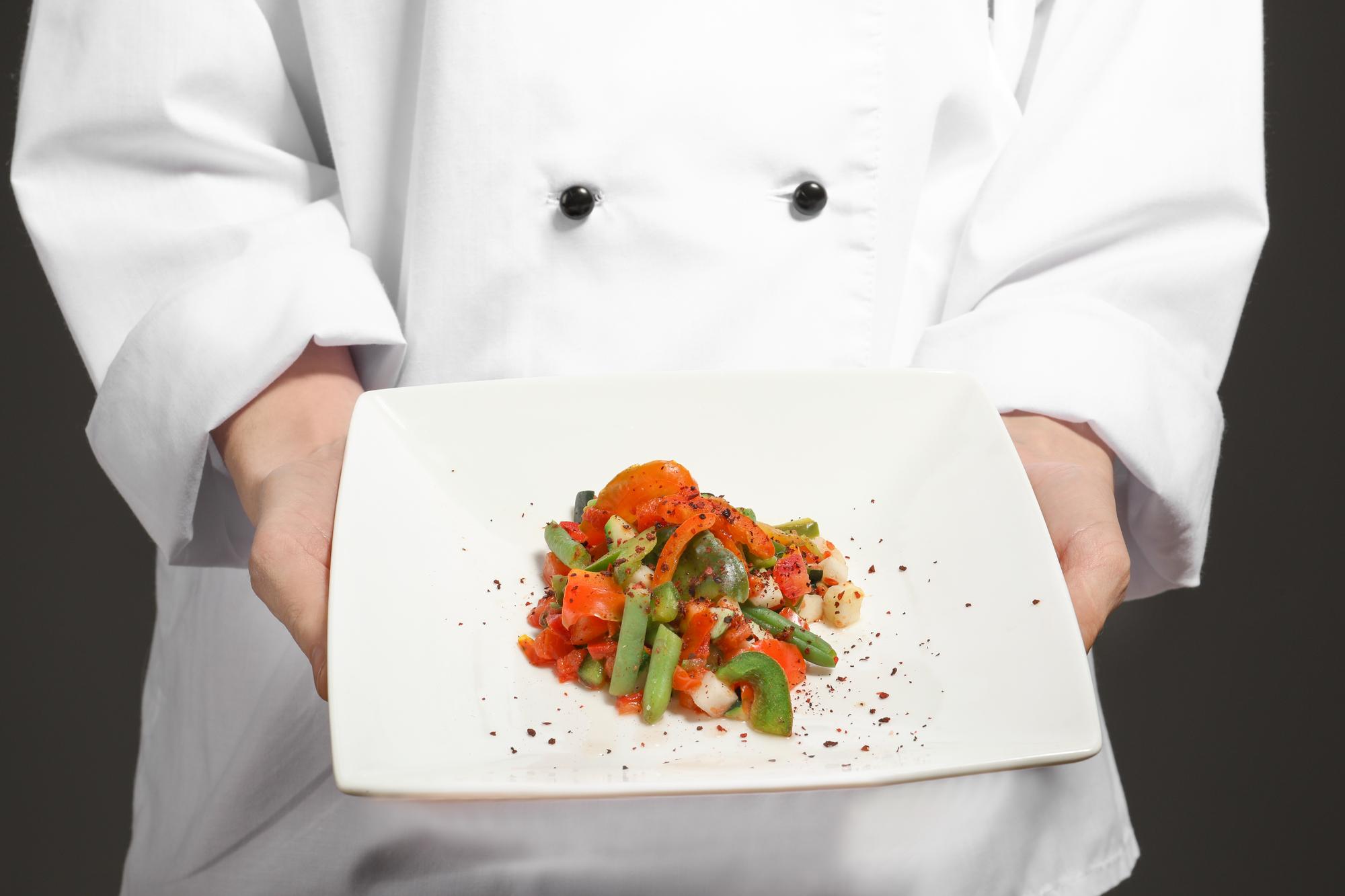 Chef che prepara un piatto in cucina professionale
